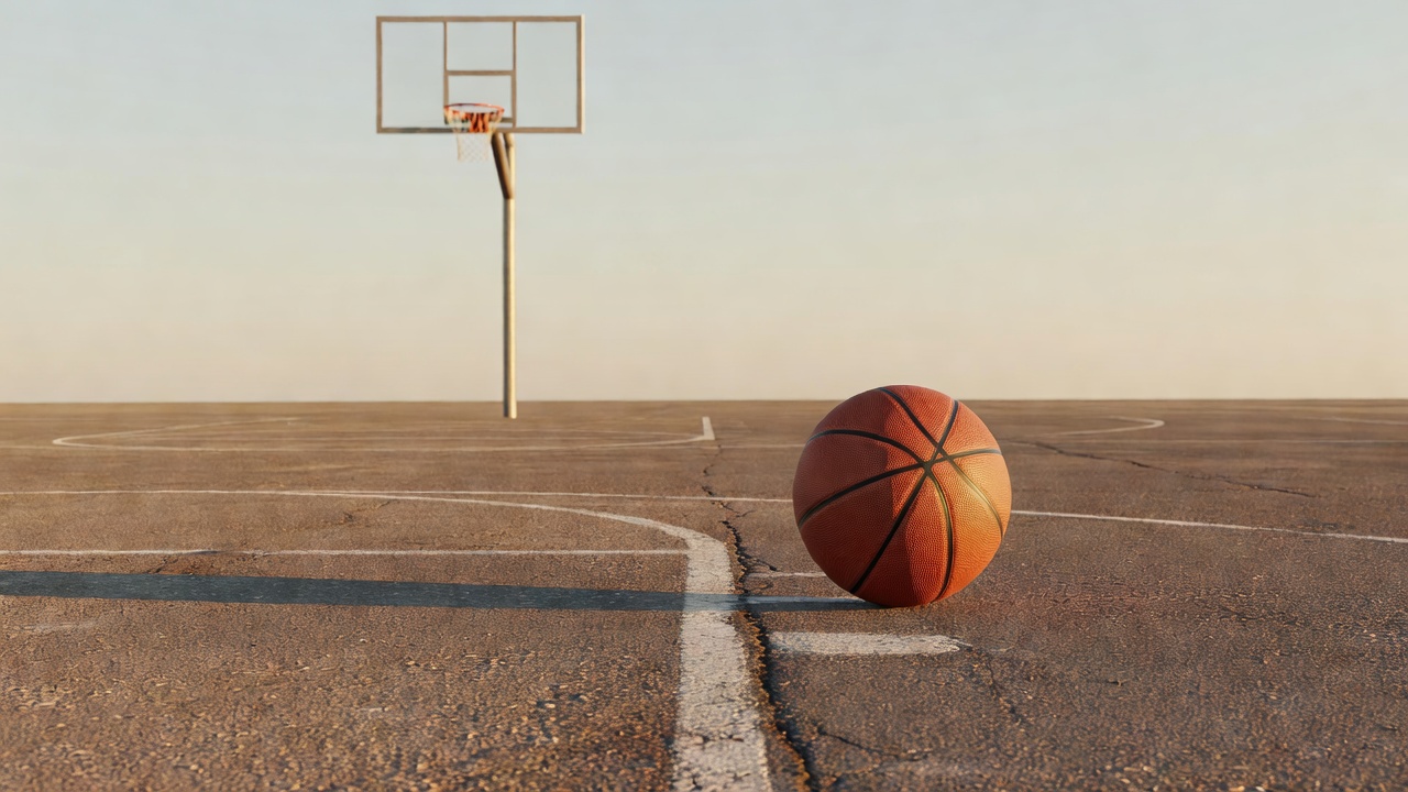 A basketball resting on an outdoor court near the free-throw line